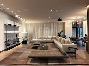 Una sala de estar moderna con un sofá modular, una mesa de centro y un comedor con una mesa y sillas.