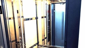 An elevator interior with metallic walls, a control panel, and a reflective surface. - Cetinkaya Suites (Istanbul)
