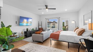 A modern bedroom with a bed, a sofa, a desk, and a large window. - King Bed & Rooftop Views Prime Bankers Hill near Balboa Park (San Diego)