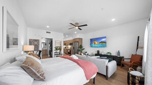 A modern hotel room with a large bed, a desk, a sofa, and a dining area. - King Bed & Rooftop Views Prime Bankers Hill near Balboa Park (San Diego)