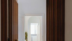A hallway with a tiled floor and wooden doors. - De Vivo Realty - Lunamare Sorrento (Sorrento)