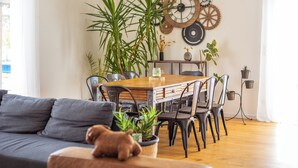 A modern living room with a sofa, dining table, chairs, and potted plants. - Modern country house - sleeps 8/10 - heated pool (Tarabel)