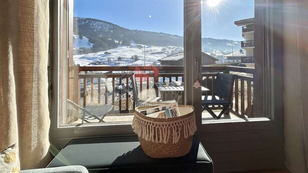 A room with a view of a snowy landscape through a large window.