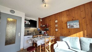 A compact living space with a kitchenette, a dining area, and a seating area.