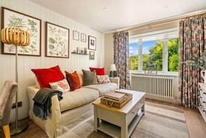 Een woonkamer met een bank, een bijzettafeltje en een radiator.