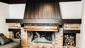 Un espace intérieur accueillant avec une cheminée en briques, un canapé et une table.