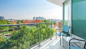 A balcony with a city view, a glass door, and two chairs. - Beautiful Garden View Pool+Hot Tub+Sauna/Large Free Parking (Vancouver)