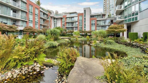 A modern apartment complex with a central courtyard featuring a pond, surrounded by lush greenery and stone pathways. - Beautiful Garden View Pool+Hot Tub+Sauna/Large Free Parking (Vancouver)