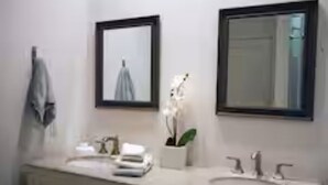 A bathroom with a white sink, a mirror, and a towel rack.