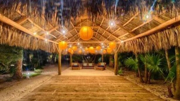 An indoor wooden structure with a thatched roof, multiple hanging spherical lights, and a central seating area. - Relaxing Garden Suite With Pool @Islamorada- Sea Turtle Suite (Islamorada)