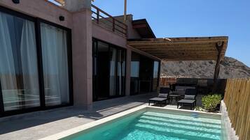 Een buitenzwembad, parasols voor strand/zwembad