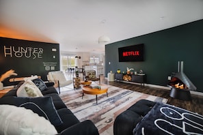 TV connectée, cheminée, table de tennis de table, livres