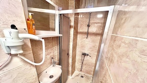 A compact bathroom with a shower, toilet, and a hand dryer. - Taksim The Capital Center Hotel (Istanbul)