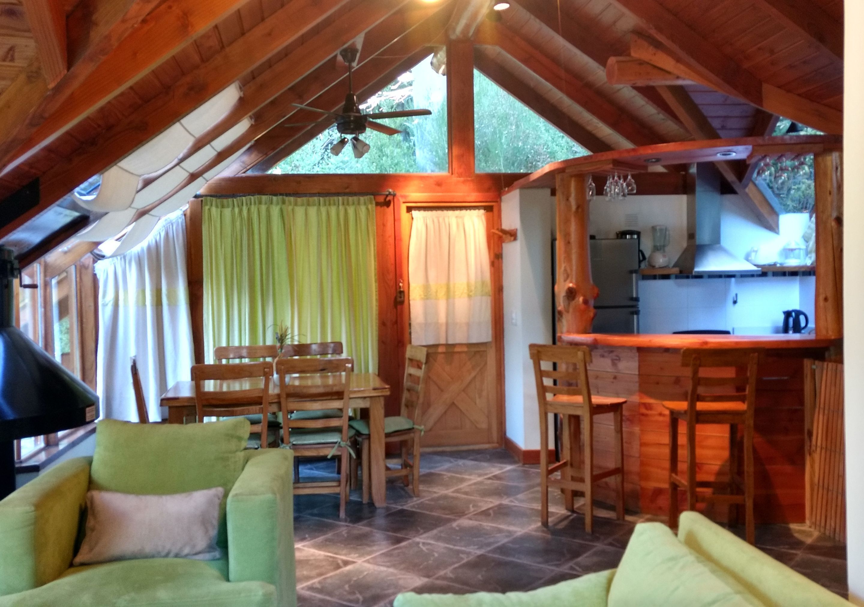 Interior acogedor de una cabaña con comedor, cocina y zona de estar.