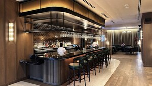 Zona de bar moderna con una barra curva, varios taburetes y un barman.
