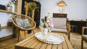 A wooden table with a tray holding a bottle of wine and a glass.