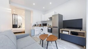 Un apartamento moderno con sala de estar, kitchenette y televisor.