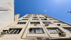 Un edificio de varios pisos con numerosas ventanas y unidades de aire acondicionado.