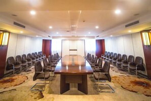 A conference room with a long table, chairs, and a carpeted floor. - Guanghua International Hotel (Nantong)