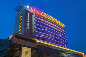A multi-story hotel with illuminated signage and a modern architectural design. - Guanghua International Hotel (Nantong)