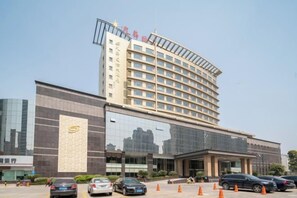 A hotel with a modern design, featuring a large glass facade and a prominent entrance. - Guanghua International Hotel (Nantong)