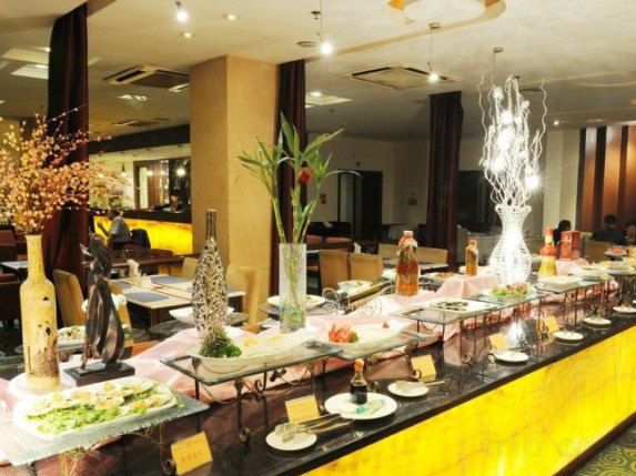 A buffet setup with various dishes and decorative elements.