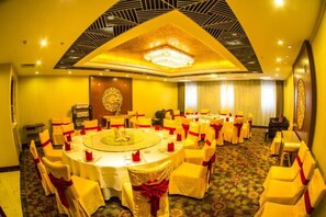 A conference room with a round table surrounded by chairs, a chandelier, and a patterned carpet. - Guanghua International Hotel (Nantong)