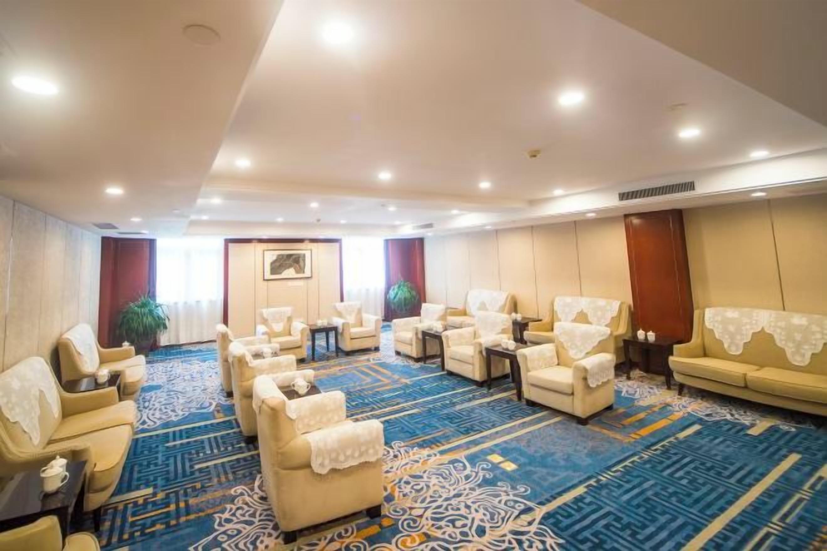 Habitación de hotel con una amplia zona de estar, un sofá y suelo alfombrado.