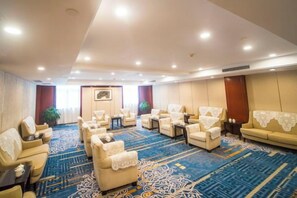 A hotel room with a large seating area, a sofa, and a carpeted floor. - Guanghua International Hotel (Nantong)