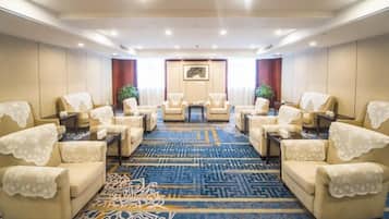 A conference room with a patterned carpet, multiple chairs, a table, and a framed picture on the wall.