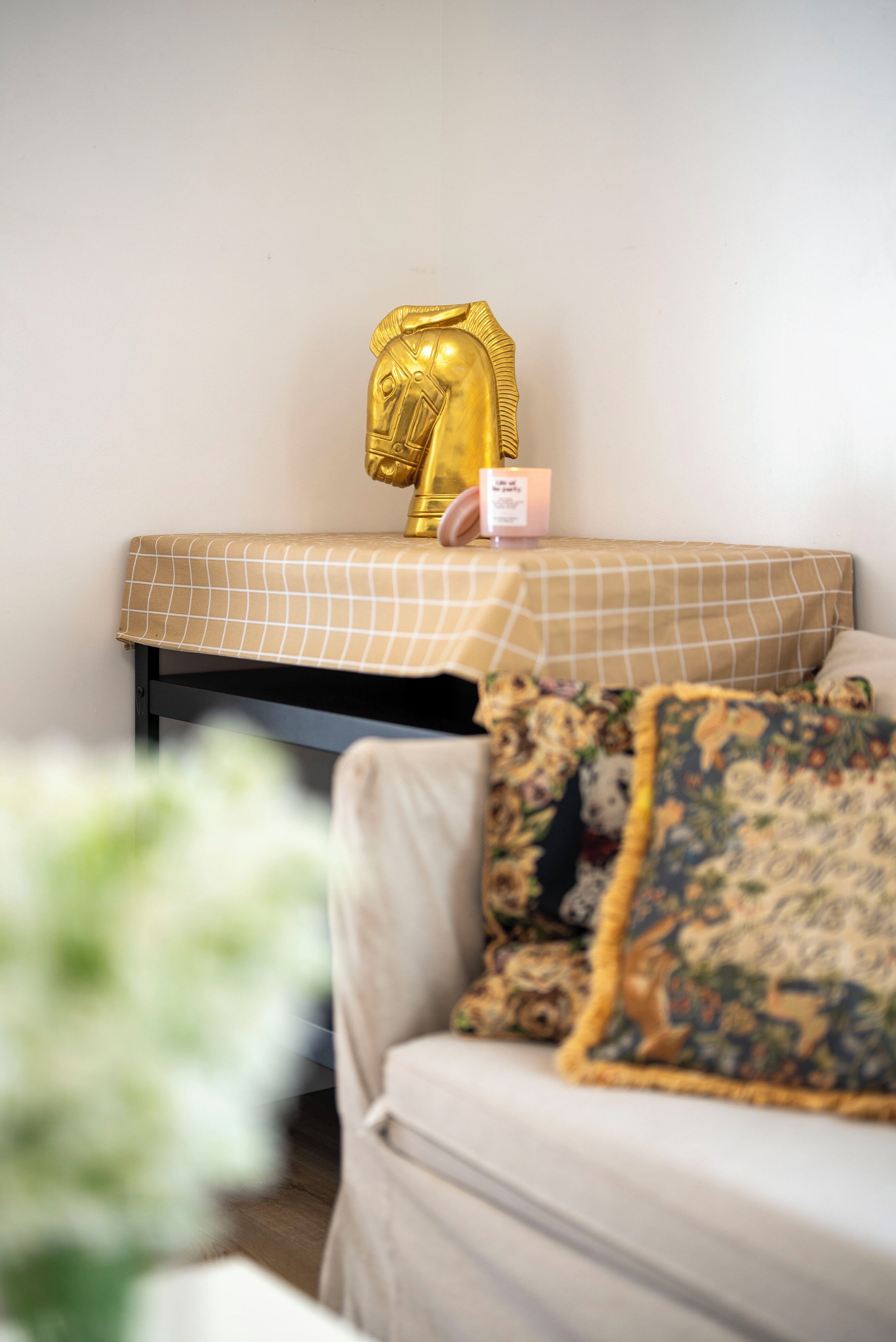 A room with a bed, a bedside table with a lamp, and a decorative headpiece on the wall.