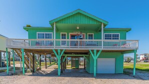 Une maison à deux étages avec un balcon, un garage et une véranda couverte.