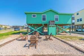 A green building with a porch and outdoor seating area. - Charming updated Surfside home with firepit - only 2 min walk to the beach! (Surfside Beach)