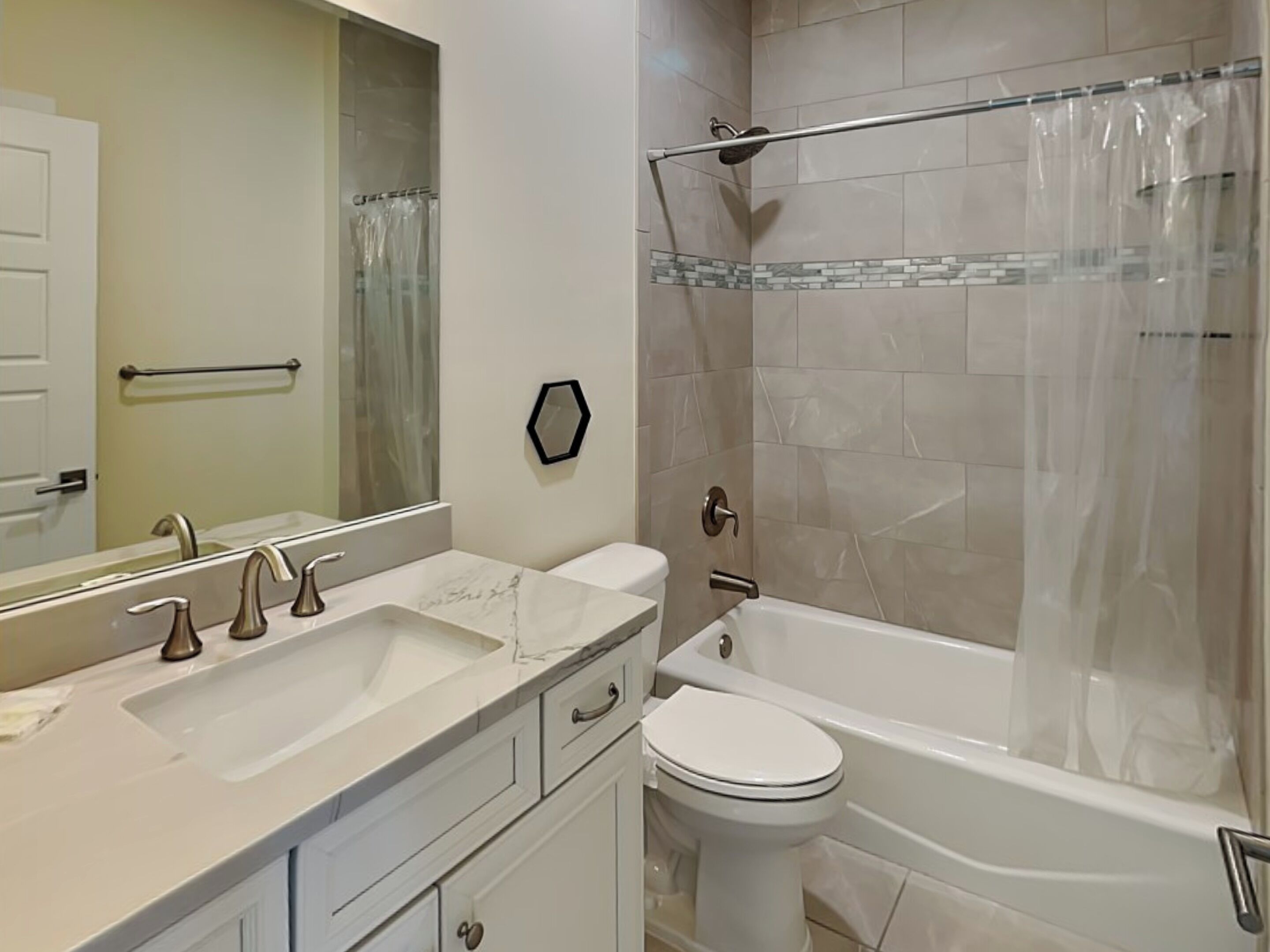 A bathroom with a double sink, a toilet, and a bathtub.