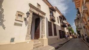 A narrow street lined with historic buildings featuring stone facades, balconies, and a clear sky. - One-bedroom apartment in historical center (Unknown)