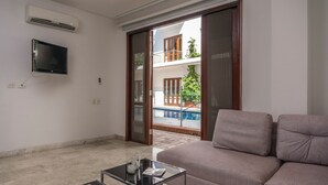 A living room with a sofa, a glass coffee table, and a flat-screen TV mounted on the wall. - One-bedroom apartment in historical center (Unknown)