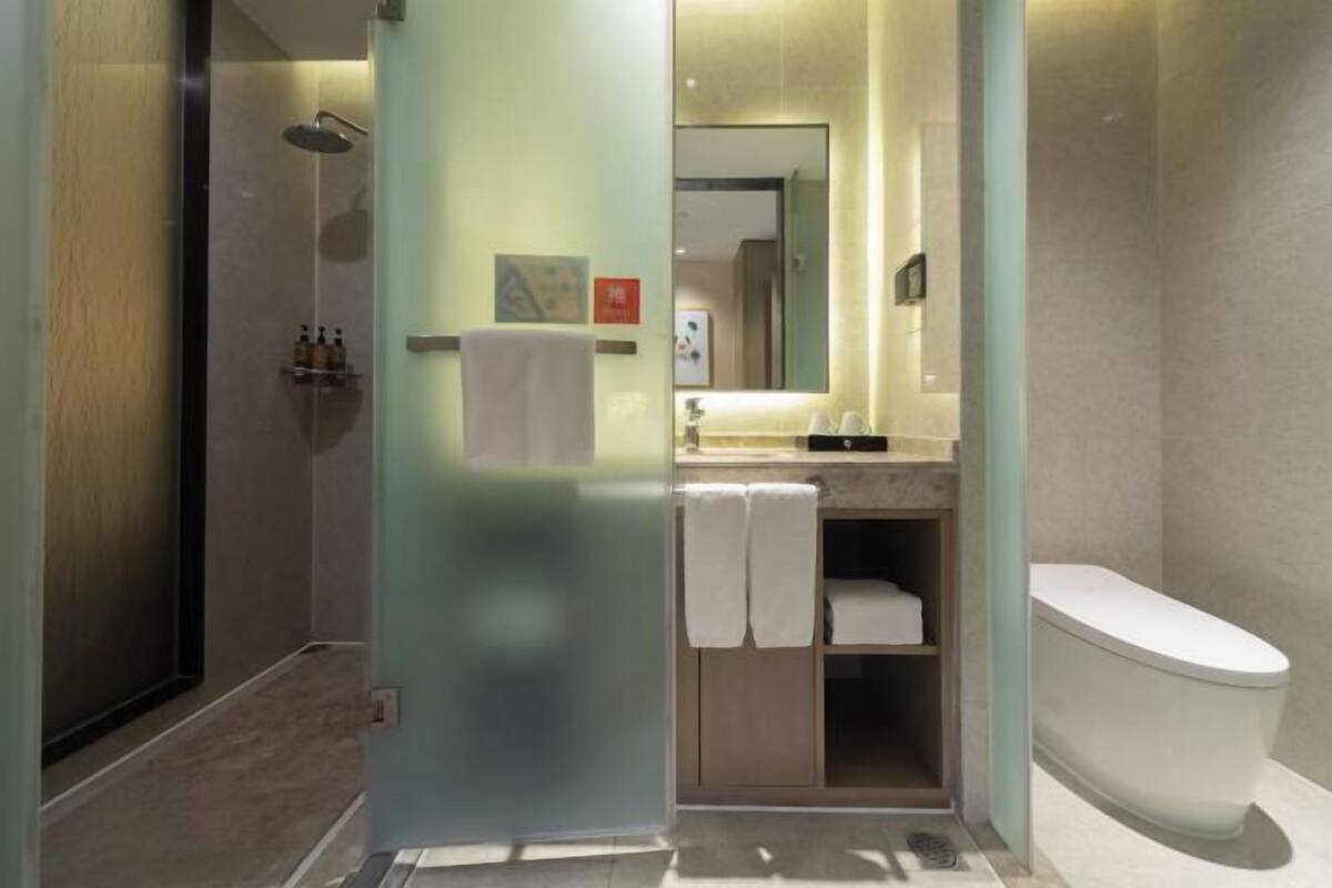 A modern bathroom with a shower, toilet, and vanity.