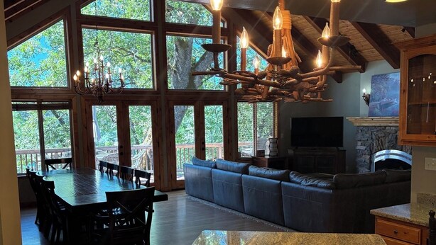 A spacious living area with a large island, a fireplace, and a television. - Bass Lake luxury cabin with lake views & boat slip (Bass Lake)