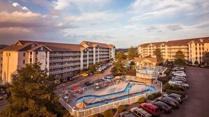 Ein Hotel mit mehreren Gebäuden, einem Schwimmbad und einem Parkplatz.