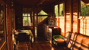 A cozy cabin interior with a dining area, a kitchen, and a seating area with a couch. - Resurreeccion (San Francisco)