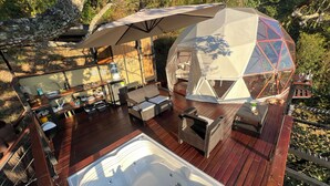A geodesic dome structure with a hot tub and outdoor seating area on a wooden deck. - Resurreeccion (San Francisco)