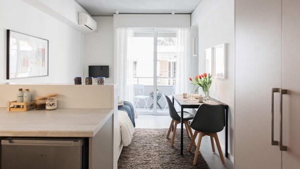 Una cucina compatta con zona pranzo, TV e vista sulla strada.