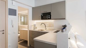 Una cucina moderna con forno a microonde integrato, macchina del caffè e lavello con porta asciugamani.