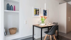 Zona pranzo moderna con tavolo, sedie, un vaso di tulipani e opere d'arte incorniciate al muro.