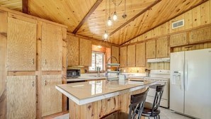 A wooden kitchen with a central island, bar stools, and a refrigerator. - Mtn & Golf Course Views: Payson Retreat! (Payson)