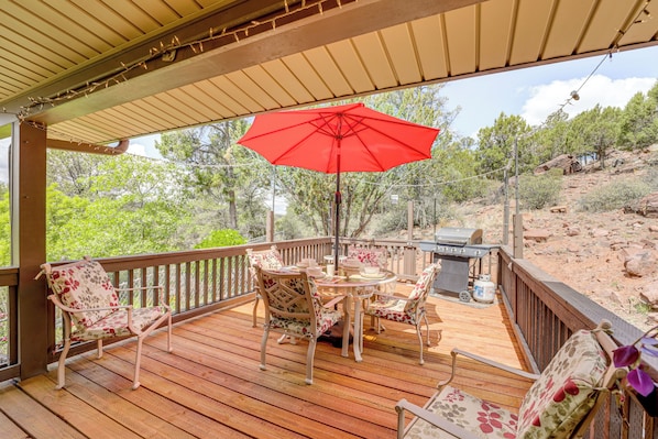 A covered outdoor deck with a red umbrella, wooden furniture, and a grill. - Mtn & Golf Course Views: Payson Retreat! (Payson)