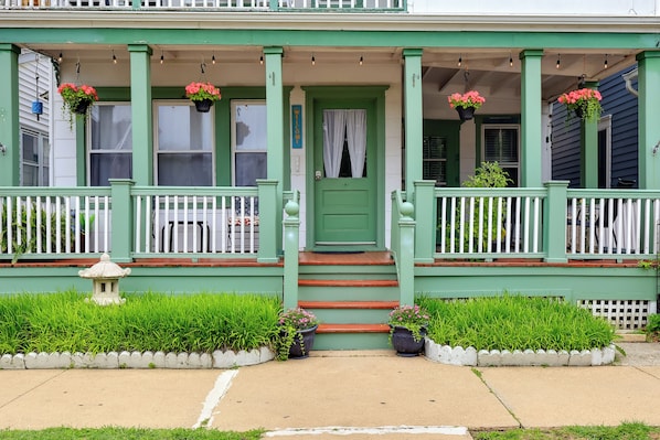 A green house with a porch, steps, and potted plants. - 5 Blocks to Beach: Apt w/ Balcony in Ocean Grove! (Ocean Grove)