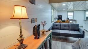 Ein modernes Wohnzimmer mit einer Couch, einer Lampe und einem Ventilator auf einem Holztisch.