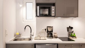 A modern kitchen with a built-in microwave, coffee maker, and stainless steel sink.