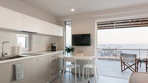Cocina moderna con comedor y balcón con vista a la ciudad.